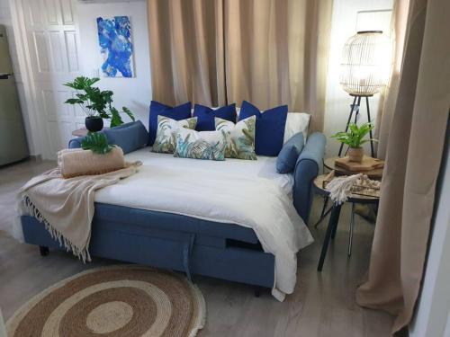 een slaapkamer met een blauw bed met kussens bij Palm Beach Paradise Vacation Rental in Palm-Eagle Beach