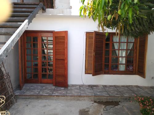 Casa blanca con puertas de madera y escalera en DPTO. LOFT en Salta