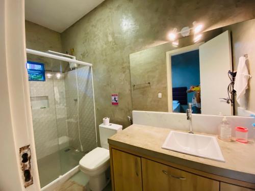 a bathroom with a sink and a shower and a toilet at Casa 4 quartos 2 Lofts Piscina in Marataizes