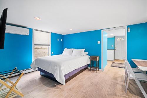 - une chambre avec des murs bleus et un lit avec un bureau dans l'établissement Ventnor Beach House, à Ventnor City