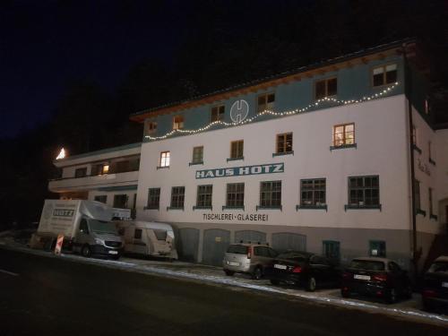 um grande edifício branco com carros estacionados em frente em Haus Hotz em Landeck
