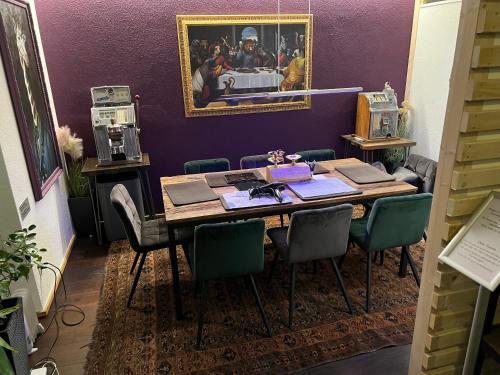 a dining room with a table with chairs and a picture at GRAND your home with common kitchens with self check-in in Engelberg
