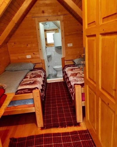 a room with two beds in a cabin at Konaci Očeva Zemlja Vikendica i Bungalovi in Mojkovac
