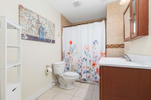 a bathroom with a toilet and a sink and a shower curtain at Cordova Dream Upper in St. Augustine