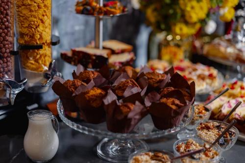 a table with a bunch of desserts on a plate at Tapis Rouge Design Boutique Hotel in Batumi
