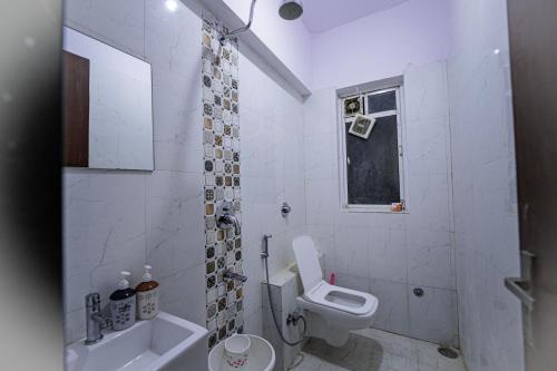 a white bathroom with a toilet and a sink at Staeg Night Sky View 2BHK - 1605 in Indore