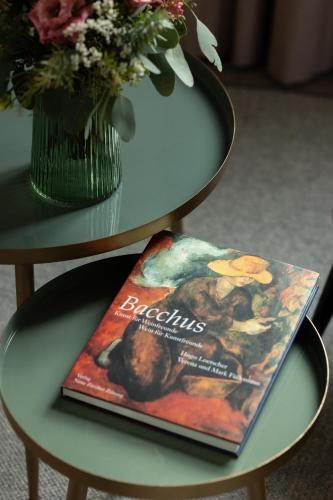 a book on a table next to a vase of flowers at DEINHARD's in Bernkastel-Kues