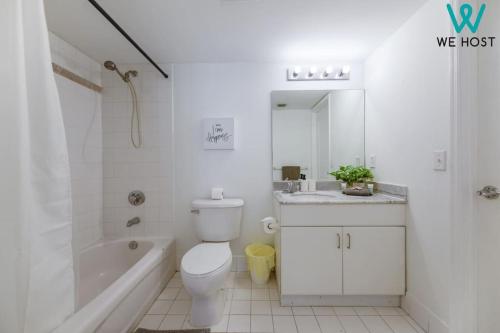 ein weißes Badezimmer mit einem WC, einer Badewanne und einem Waschbecken in der Unterkunft We Host - Condo Top Amenities City- Bay View in Miami