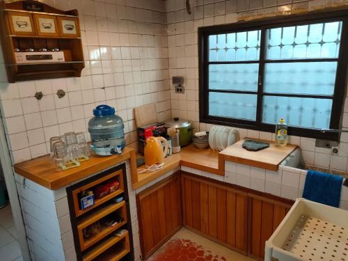 eine kleine Küche mit einer Theke und einem Fenster in der Unterkunft Old Mamaboy Marines Hostel獨立包棟三間雙人雅房 in Kaohsiung