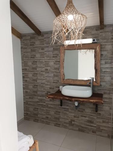 La salle de bains est pourvue d'un miroir sur un mur en briques. dans l'établissement VILLA ÉLISHA, à Saint-Louis