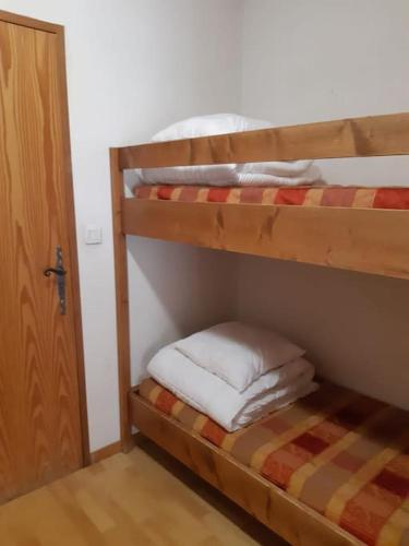 Ce dortoir comprend 2 lits superposés et une porte. dans l'établissement Studio équipé / proche du centre, à Samoëns