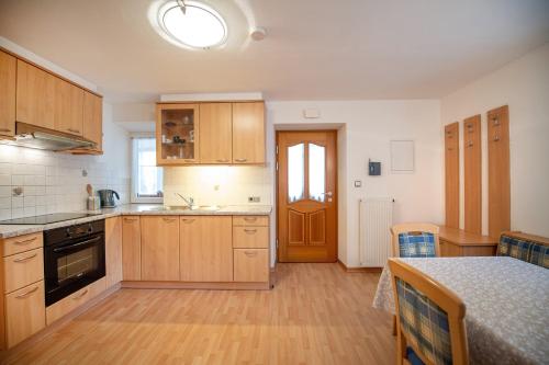 a kitchen with wooden cabinets and a table in it at Central Apartments Cristlpek in Ortisei