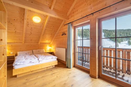 1 dormitorio en una cabaña de madera con cama y ventana en Veselý Svišť Chalet Lachtal en Lachtal