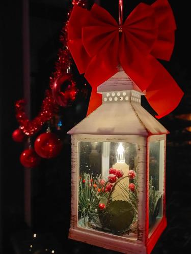 a christmas lantern with a red bow on top at Casa cu Flori in Buşteni