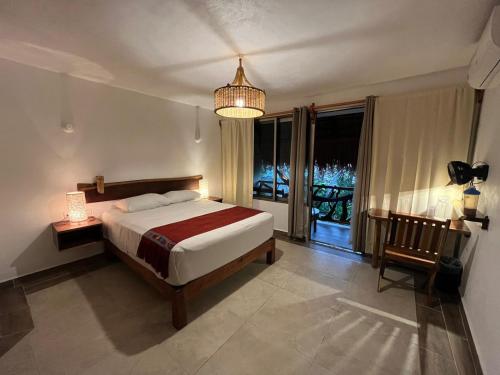 a bedroom with a bed and a large window at Casa Lamat in Bacalar