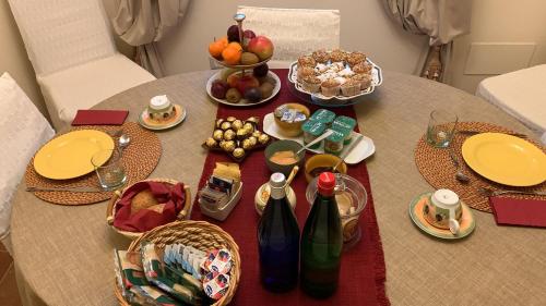 a table with plates and bottles of wine and fruit at Altra Meta b&b in Gubbio