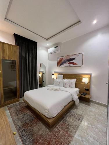 um quarto com uma grande cama branca num quarto em Bricks Residence em Lekki