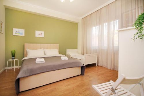 1 dormitorio con 1 cama y 1 silla en Perfect spacious apartment en Almaty