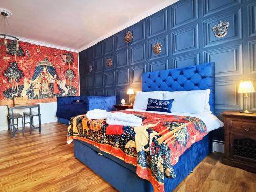 Dormitorio azul con cama y mesa en Ricky Road Guest House - "Wizard Studio Room" Available to Book Now en Watford