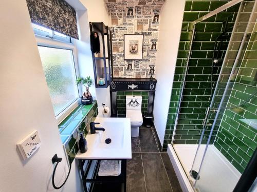 y baño con aseo, lavabo y ducha. en Ricky Road Guest House - "Wizard Studio Room" Available to Book Now en Watford