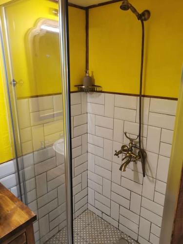 a bathroom with a shower with yellow walls and white tiles at Tiny House in Garden with Sea View in Karamusal
