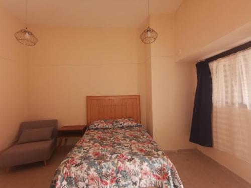 ein Schlafzimmer mit einem Bett, einem Stuhl und einem Fenster in der Unterkunft Nido Colibrí - Zona Remate de Paseo Montejo in Mérida