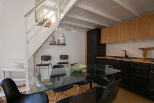 una cucina con un tavolo di vetro e sedie nere di Catania Central rooms a Catania