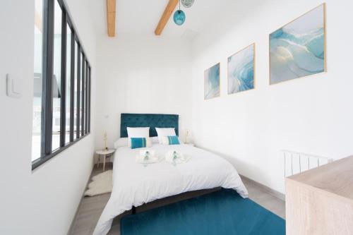 a bedroom with a bed with a blue rug at L'Émeraude in Malesherbes