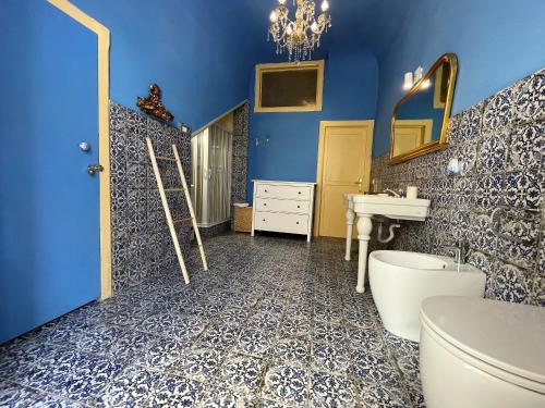 a blue bathroom with a toilet and a sink at Mid Modern Akragas Home in Center with Sea View in Agrigento