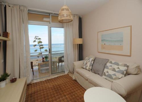 a living room with a couch and a view of the ocean at El Rincón de Inés frente a la playa in Las Palmas de Gran Canaria