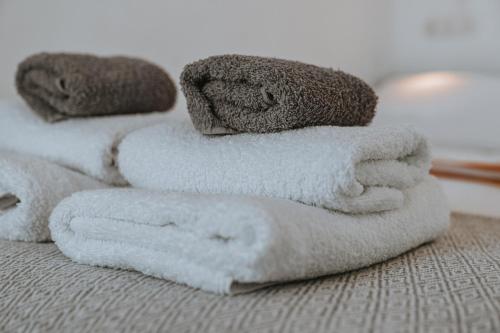 a pile of towels sitting on top of a bed at Serifos Sugar Cubes in Serifos Chora