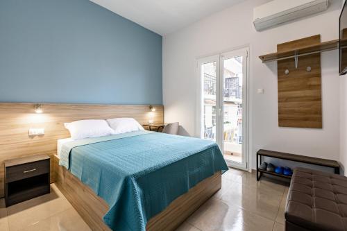 a bedroom with a bed with a blue bedspread at ATHENAIS CENTRAL in Litochoro