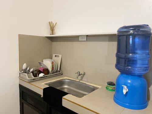 a blue water bottle sitting next to a kitchen sink at Lara's Guesthouse Siargao in General Luna