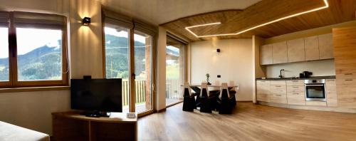 a living room with a television and a kitchen at Chalet MAOL Luxury Living in Valdidentro