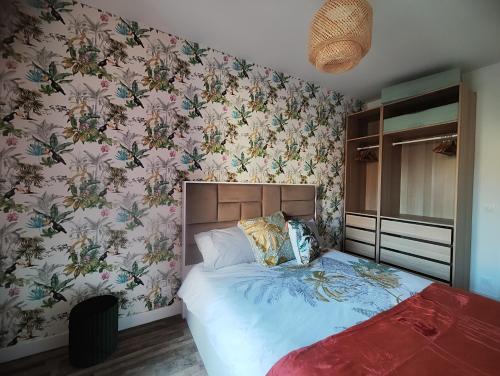 a bedroom with a bed with floral wallpaper at Jacuzzi privatif - Suite Amazonie - 1 ou 2 chambres in Chaumes-en-Brie