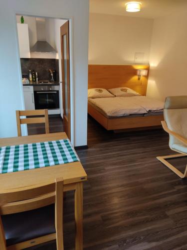 une chambre avec deux lits, une table et une cuisine dans l'établissement Apartment Reichenhall, à Bad Reichenhall