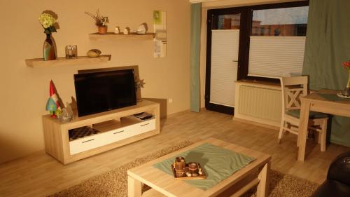 ein Wohnzimmer mit einem TV und einem Tisch in der Unterkunft Appartement Ursula Eck in Bergisch Gladbach