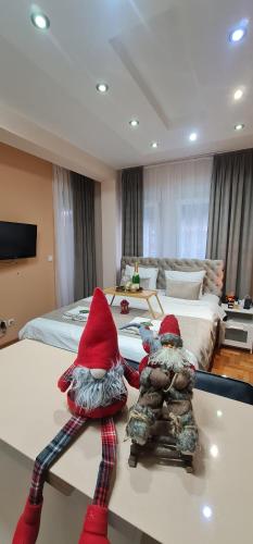 two gnomes are sitting on a table in a bedroom at Design Apartment BUSINESS LUX 4 STAR "RIO" Completely Business LUX place in the City Center & FREE INCLUDED Industry optical WiFi & NETFLIX & Keyless code entry & FULL SMART APP & Kitchen & Washing machine & Wide terrace & SECURE 2 Parking place in Ćuprija