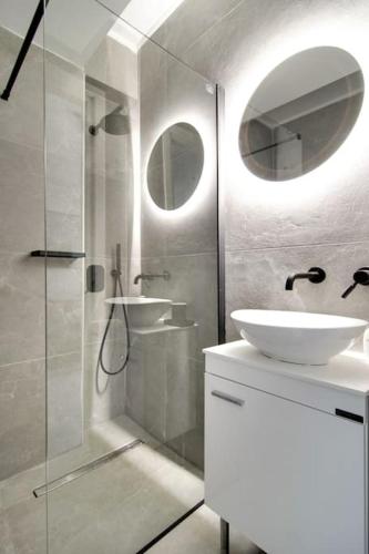 a white bathroom with a sink and a shower at MyPLACE Premium Apartments in Ioannina