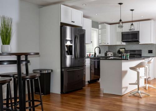 uma cozinha com um frigorífico de aço inoxidável e armários brancos em Twin XL Bed - Boston - RM 1 em Stoneham