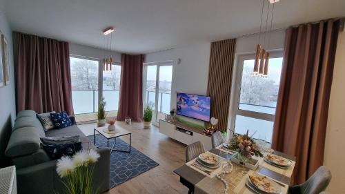a living room with a couch and a tv at Apartament Perła Zachodu View & Spa Sagaris Dziwnów in Dziwnów