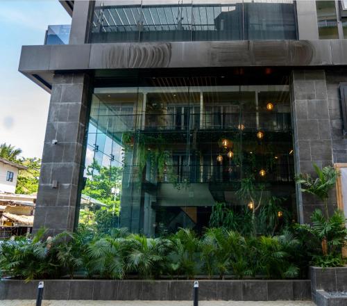 a building with a bunch of plants in front of it at H Hotel El Nido - Vegan Friendly Hotel Managed by H Hospitality Group in El Nido