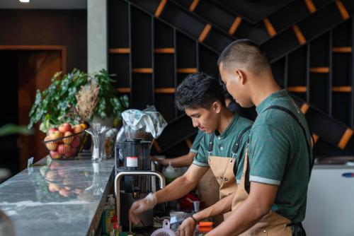 two men standing in a kitchen preparing food at H Hotel El Nido - Vegan Friendly Hotel Managed by H Hospitality Group in El Nido