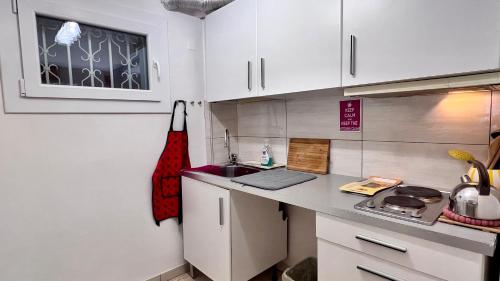 a small kitchen with white cabinets and a sink at Behind On The Canalside Venice in Venice