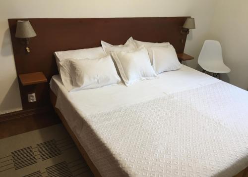 a bed with white sheets and pillows in a room at Casa do Largo - Açores in Ponta Delgada