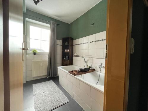 een badkamer met een groot bad en een raam bij Ferienwohnung Augenblick in Kurort Altenberg