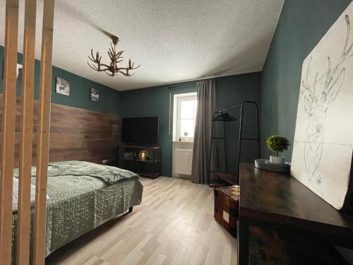 ein Schlafzimmer mit einem Bett und einem TV in der Unterkunft Ferienwohnung Augenblick in Kurort Altenberg