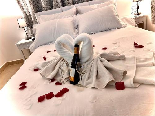 Una cama con una botella de vino y rosas rojas en Dream, en Midrakh ‘Oz