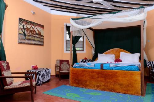 a bedroom with a bed with a canopy at Kaure Sand Beach Lodge in Uroa
