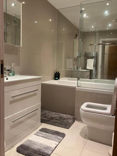 e bagno con lavandino, servizi igienici e vasca. di Luxury 3-Bedroom Townhouse in Hackney a Londra